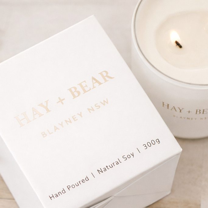 Candle packaging with 'HAY & BEAR' branding on a neutral background