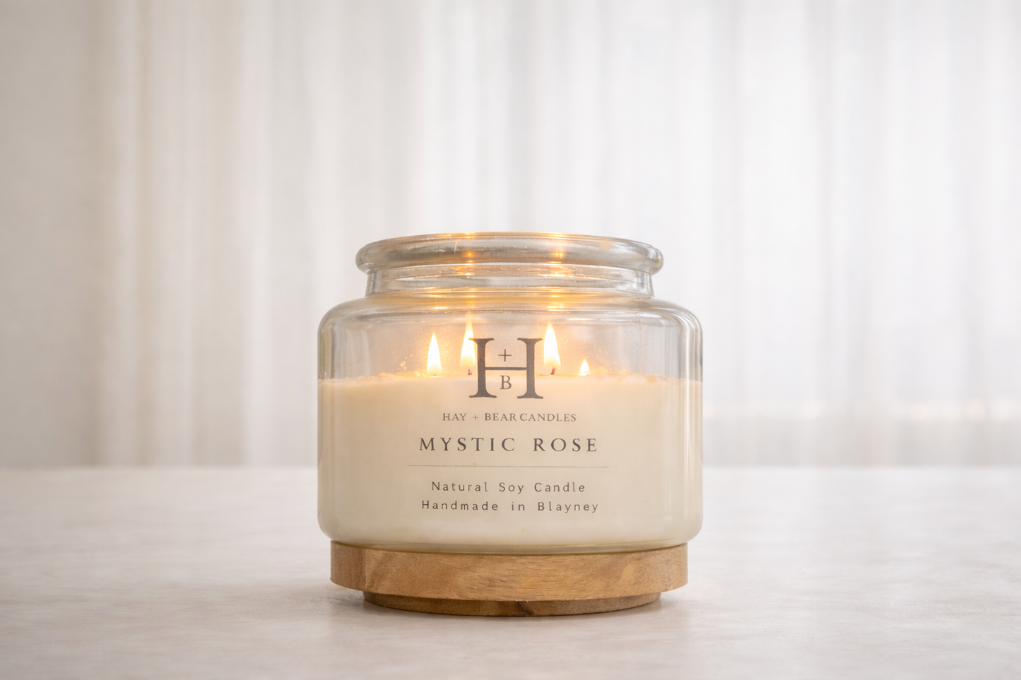 Glass candle with wooden base labeled 'Mystic Rose' on a white background